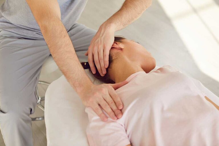 Clinician applying a controlled manual adjustment to a patient’s mid-back in a bright treatment room.